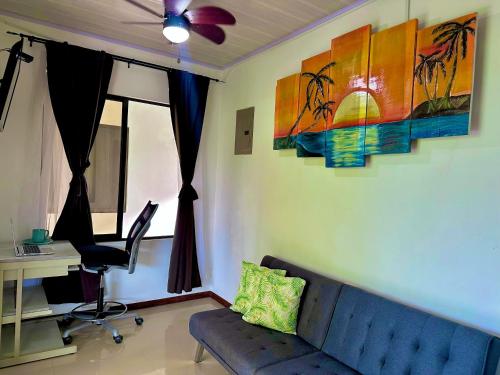 a living room with a blue couch and a desk at Villas Mapache del Caribe in Puerto Viejo
