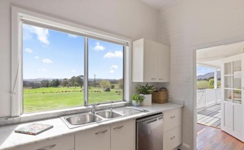 a kitchen with a sink and a large window at Willow Creek Farm Cottage in Verona
