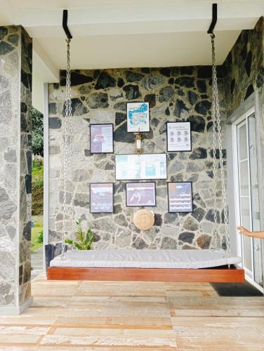 a stone wall in a room with a swing at eSKPe to Blackwood in Haputale