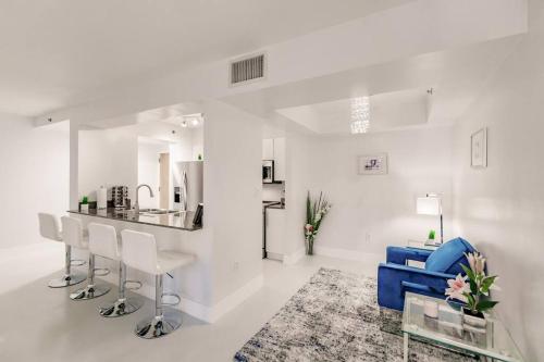 een witte woonkamer met een bar en een blauwe bank bij Upscale Brickell 2 bedroom with water views and free parking in Miami
