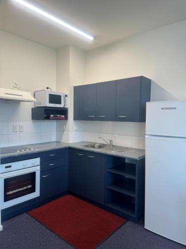 a kitchen with blue cabinets and a white refrigerator at Best Western Wellington in Wellington