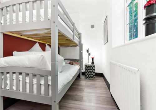 ロンドンにあるRadiant Serenity: 2BR Flat Sleeps 5 -Warm Ambianceのベッドルーム1室(二段ベッド2台、階段付)