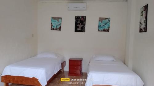 een kamer met 2 bedden en een dressoir. bij Lugar Tranquilo in Puerto Ayora