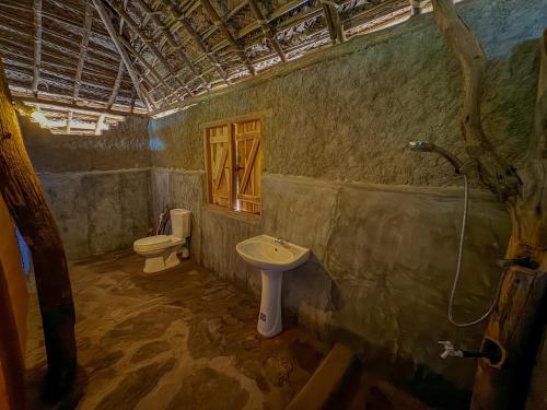 a bathroom with a sink and a toilet at Glimra eco lodge in Hambegamuwa