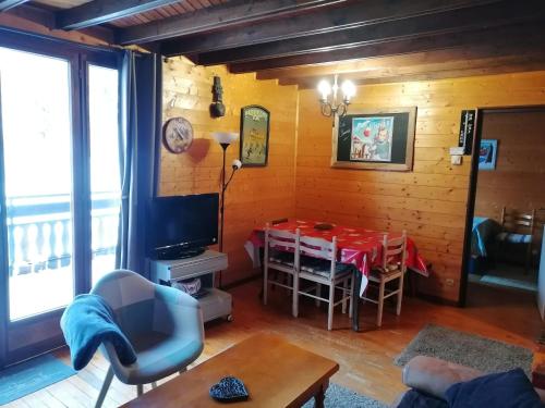 un salon avec une table et un tissu de table rouge dans l'établissement Chalet savoyard avec terrasse, proche des pistes et vue sur montagne - FR-1-459-129, à La Clusaz