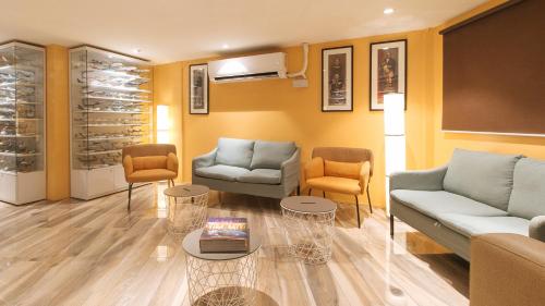 a living room with couches and chairs and tables at RedDoorz at Hotel Rosemarie in Manila