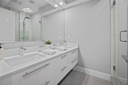 a white bathroom with a sink and a shower at City Oasis By Meridian Park (Chapin 1) in Washington