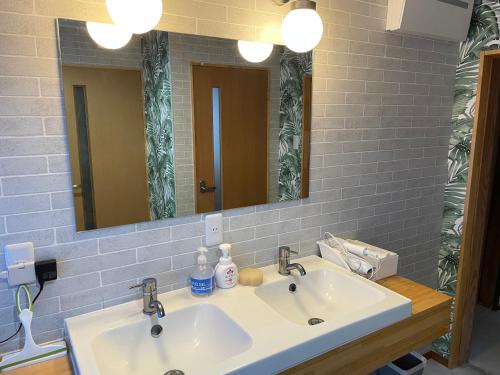 a bathroom with two sinks and a mirror at 和良ポポハウス in Gujo
