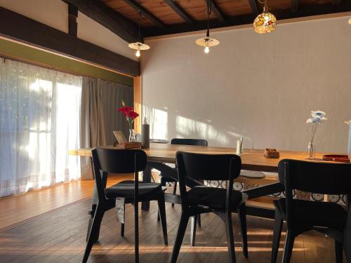 comedor con mesa de madera y sillas en 和良ポポハウス, en Gujō