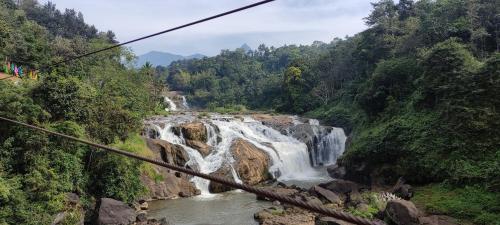 a view of a waterfall from a suspension bridge at Munnar Village Homes in Munnar