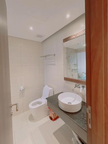 a white bathroom with a sink and a toilet at Mia Apec Mandala Phú Yên in Tuy Hoa