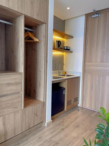 a kitchen with wooden cabinets and a sink at Mia Apec Mandala Phú Yên in Tuy Hoa
