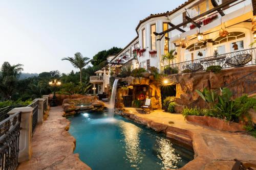 a pool in front of a building with a waterfall at BEL AIR LUXURY VILLA 6 bed rooms in Los Angeles