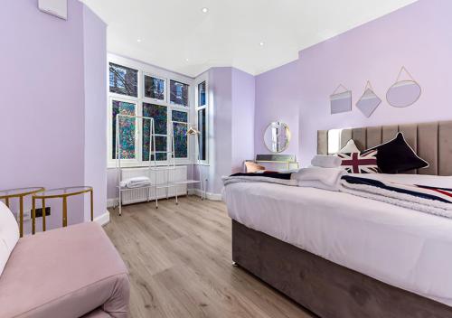 ロンドンにあるAmazing 2 Bedroom flat in Londonの紫の壁のベッドルーム1室(大型ベッド1台付)