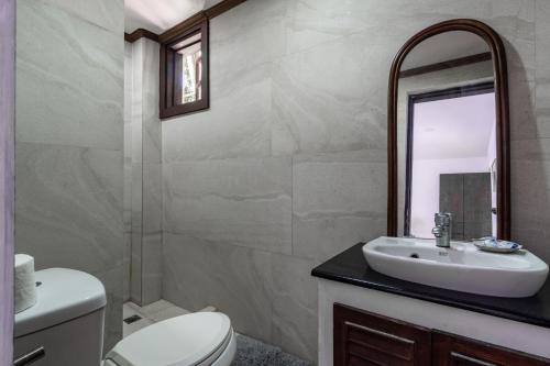 ein Badezimmer mit einem Waschbecken, einem WC und einem Spiegel in der Unterkunft The Red Hen Homestead in Batangas City