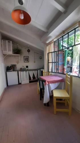 a room with a table and chairs and a kitchen at Bataclana Hospedaje y Residencia en Caminito in Buenos Aires