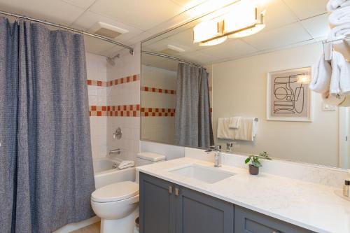 900 SQFT 2 Bed 2 Bath Renovated Suite at Cascade Lodge in Whistler Village Sleeps 6 في ويسلار: حمام مع حوض ومرحاض ومرآة