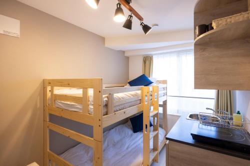 a bedroom with two bunk beds and a kitchen at Retaw Hills WASEDA in Tokyo