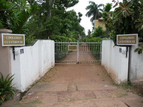 a gate in a fence with two signs on it at Cinnamon Bungalow in Negombo