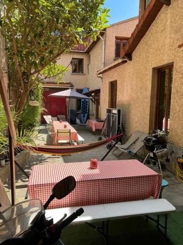 - une terrasse avec une table et un bateau dans un bâtiment dans l'établissement Spacious Private House 160sqm Prime Location with Yard and Parking for 2 Cars, à Saint-Ouen