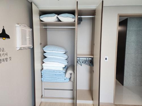 a walk in closet with a mirror and towels at Ungcheon Hotel Travel Bag in Yeosu