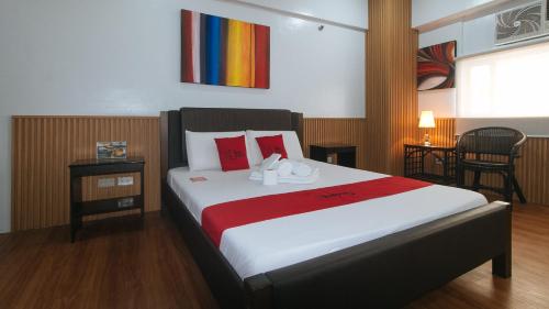 Un dormitorio con una cama con zapatos. en RedDoorz at BP International near SM Manila en Manila