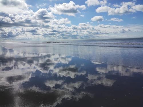 a reflection of clouds in the water on the beach at Casa Mar in La Lucila del Mar