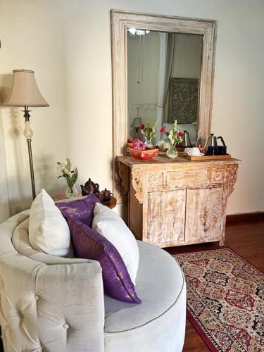 a living room with a white couch and a mirror at Kandjeng Puri Kailas Canggu in Sempidi
