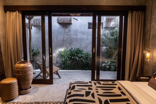 a bedroom with a door open to a patio at Kano Twin in Canggu