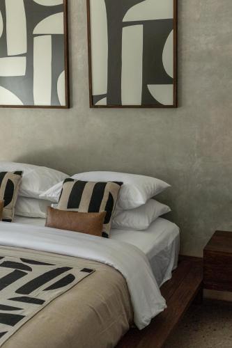 a bedroom with a bed with two mirrors on the wall at Kano Twin in Canggu
