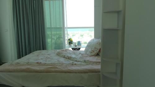 ein unverbautes Bett in einem Schlafzimmer mit einem Fenster in der Unterkunft Apartment in Al Sufouh 1st - Comfortable Home with 5 iconic views in Dubai