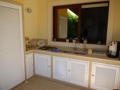 a kitchen with a sink and a window at White and Blue Holidays in Marina di Modica