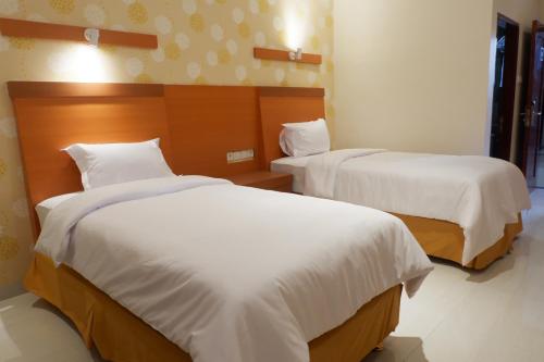 a hotel room with two beds with white sheets at Agape Hotel Haranggaol in Haranggaul