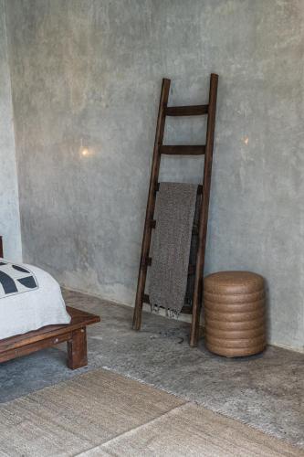 a ladder in a room with a bed and a stool at Kano Twin in Canggu