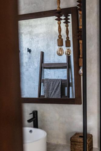 a bathroom mirror with a sink and a toilet at Kano Twin in Canggu