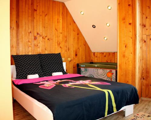 a bedroom with a bed with a wooden wall at Apartment Sea Star in Burgas