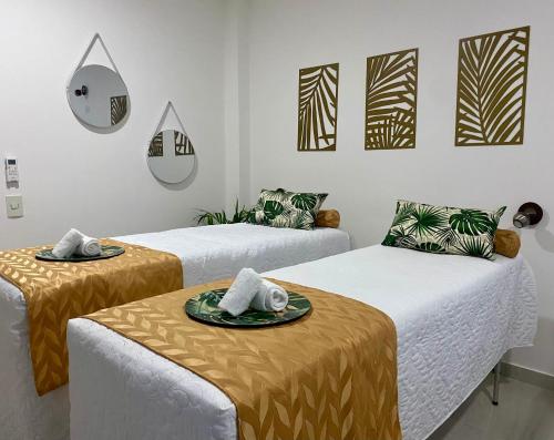 ein Zimmer mit 3 Betten mit Tellern darauf in der Unterkunft Makena La Boquilla Beach Hostel in Cartagena de Indias