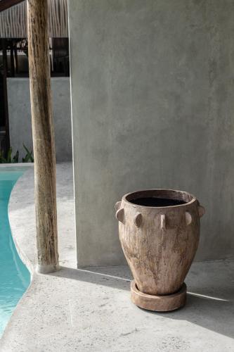 a vase sitting on the ground next to a pool at Kano Twin in Canggu