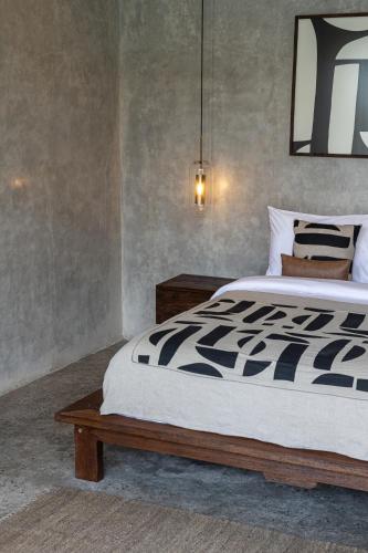 a bedroom with a large bed and a table at Kano Twin in Canggu