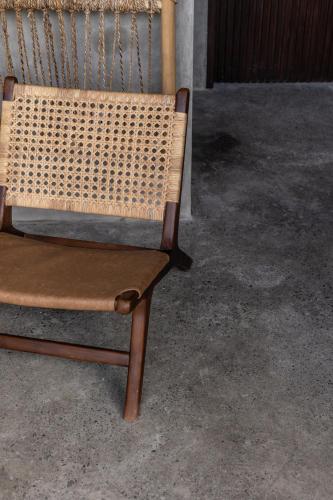 a wicker chair sitting next to a building at Kano Twin in Canggu