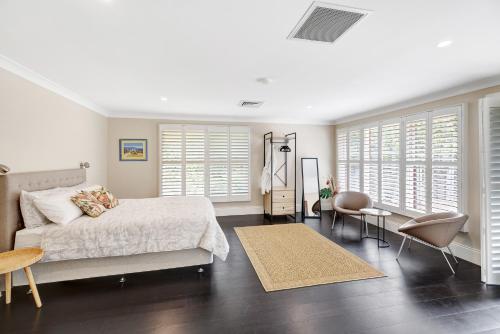 a bedroom with a bed and a table and chairs at Birches Mudgee in Mudgee