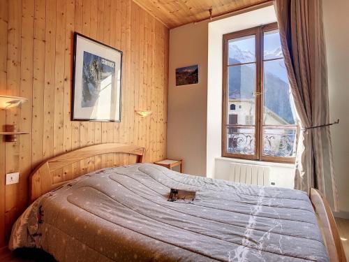 1 dormitorio con cama y ventana en Appartement Chamonix-Mont-Blanc, 4 pièces, 8 personnes - FR-1-507-25, en Chamonix-Mont-Blanc