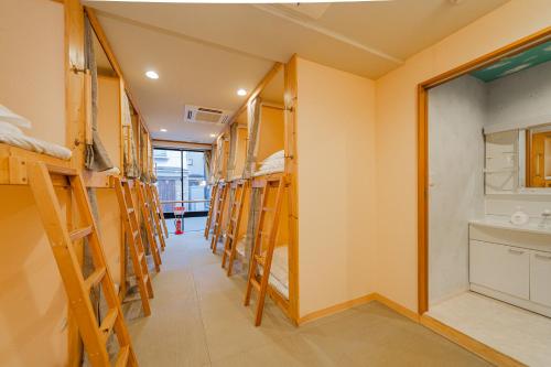 ein Zimmer mit vielen Etagenbetten in der Unterkunft TOKYO E JOY INN （East Nipoori Branch） in Tokio