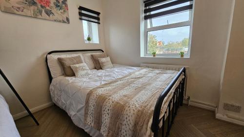 Bett in einem Schlafzimmer mit Fenster in der Unterkunft Bros Inn Hotel in London