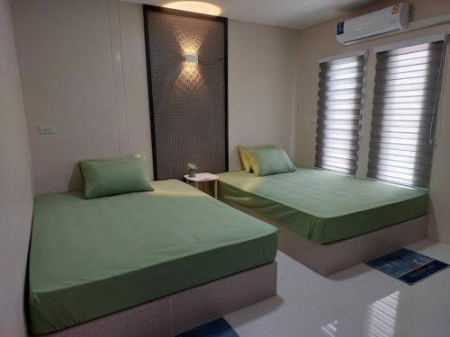 a bedroom with two beds and a window at ริมธารริเวอร์เพลส in Surat Thani