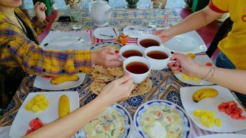 Un groupe de personnes assises à une table avec de la nourriture dans l'établissement Mahee Villa & Ayurvedic Spa, à Dambulla