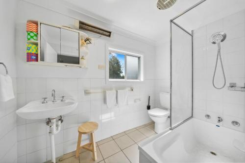 a white bathroom with a sink and a toilet at Freelander Retreat in Katoomba