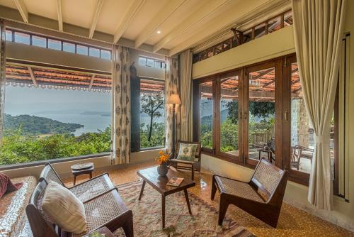 a living room with a view of the ocean at SaffronStays Sunkissed - 2 Bedroom Infinity Pool Villa in Mulshi in Mulshi