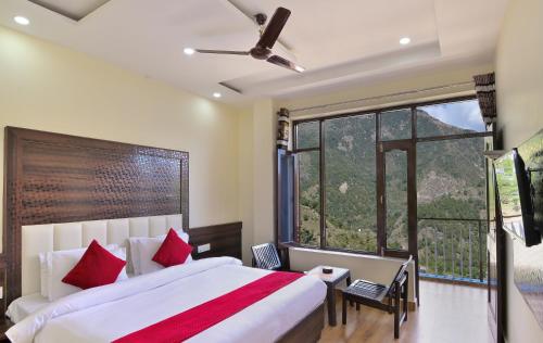 a bedroom with a large bed with red pillows at Hotel Nature View near Mall Road in Dharamshala