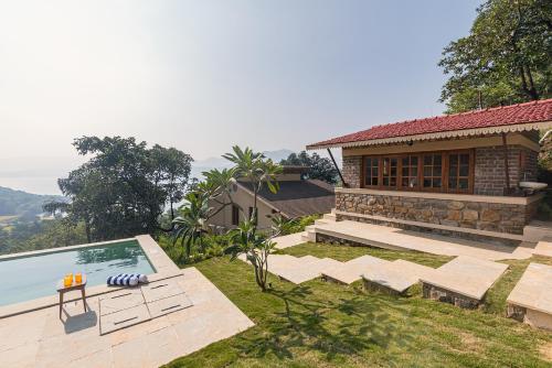 a villa with a swimming pool and a house at SaffronStays Sunkissed - 2 Bedroom Infinity Pool Villa in Mulshi in Mulshi